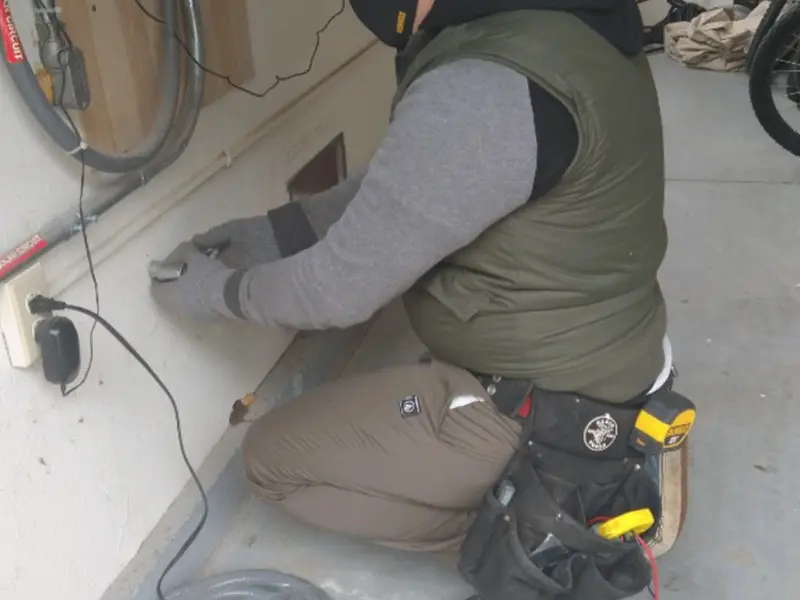 Electrician performing outlet wiring in a Lincoln Heights garage